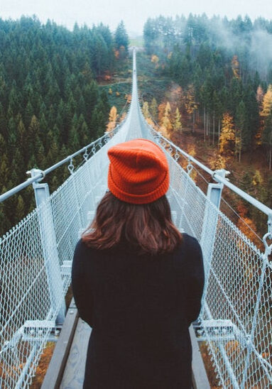 Woman crossing a bridge seeking purpose through intuitive, theta, psychic healing